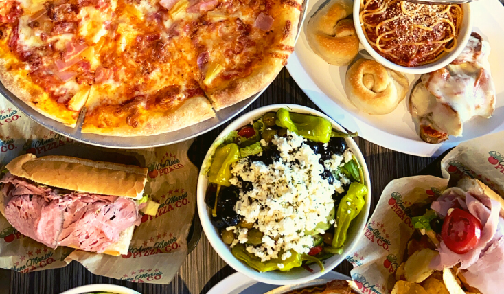 Overhead picture of many catering food options laid out on table.