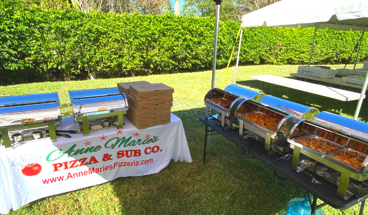 A picture of tables and tents covered with food at a catered event.