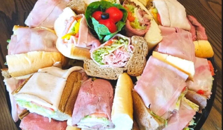 A sub platter on a circular tray shown on the event catering page for website visitors to view that quality of the sandwiches.